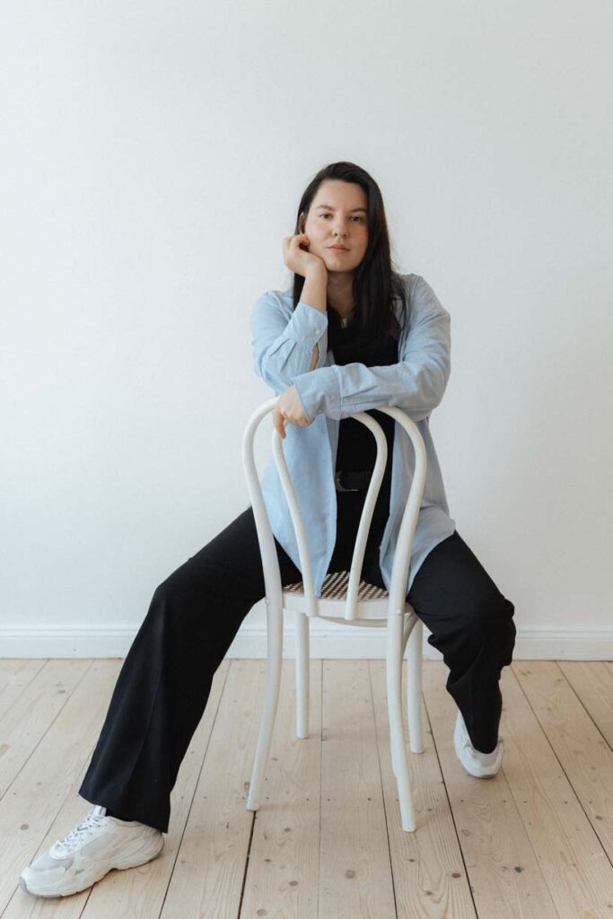 Woman sitting on the chair oddly